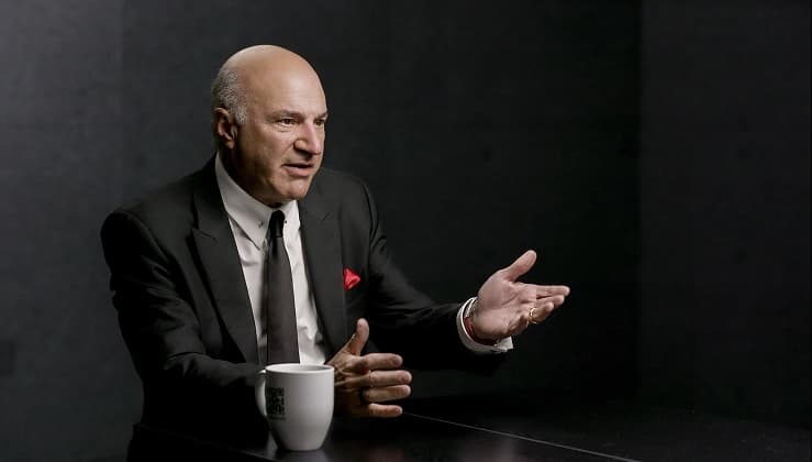 Kevin O'Leary speaking with coffee cup on table
